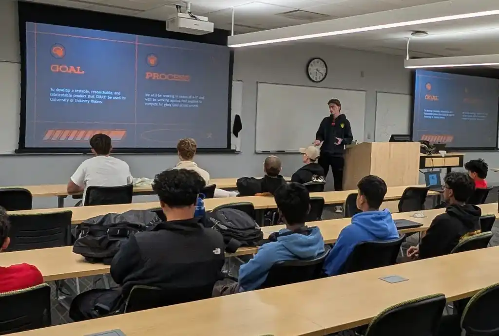 A photo of a presenter and an audience seven people