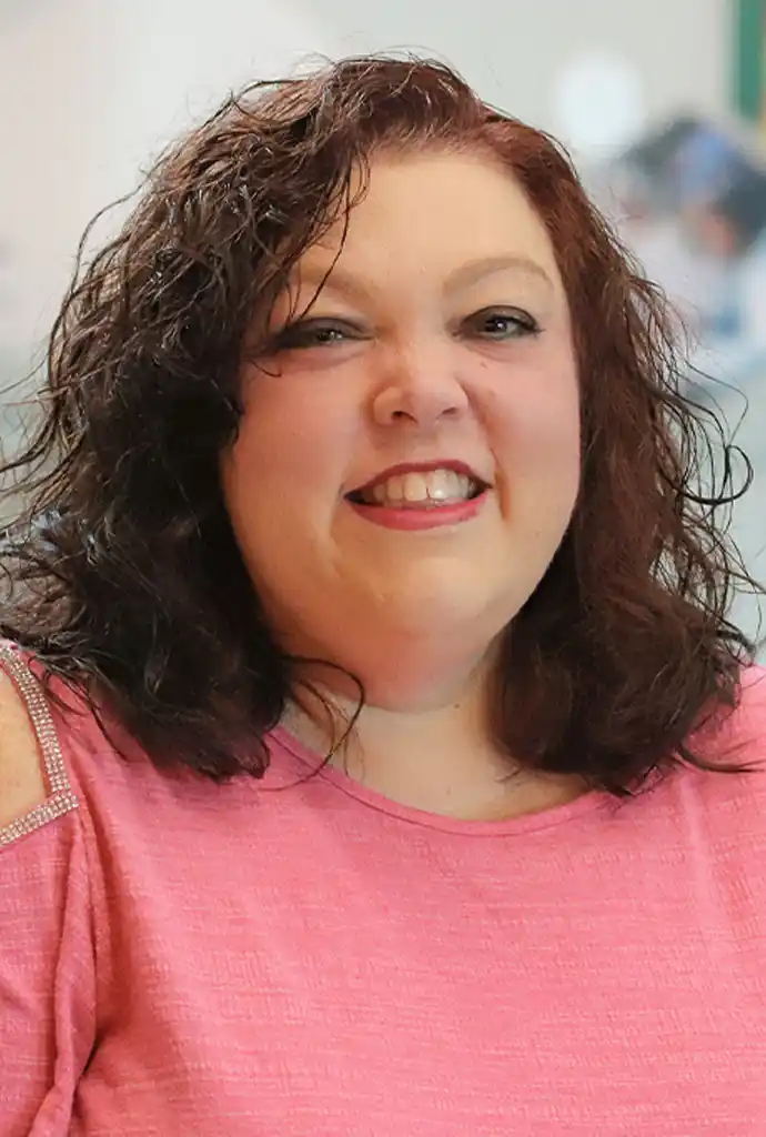 A portrait photo of a woman in a pink top