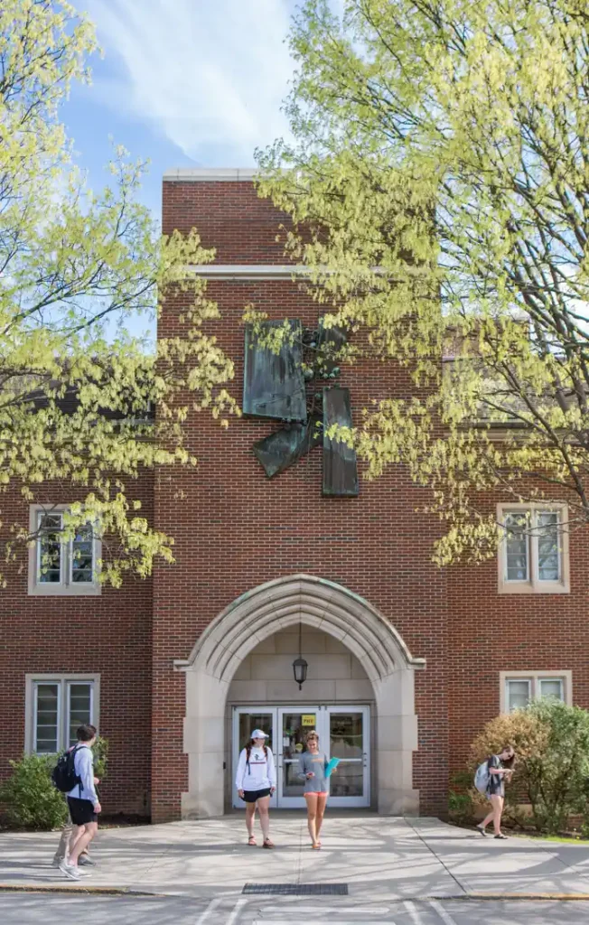 Four people in front of the red brick Nielsen Physics Building