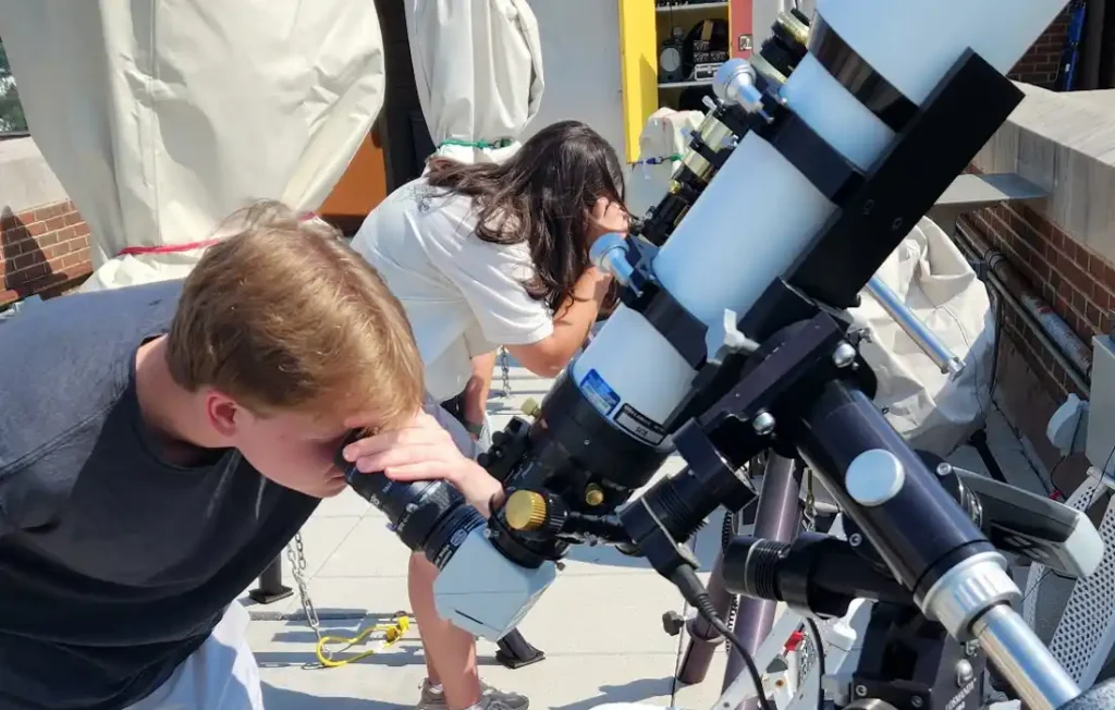 Two people looking through telescopes for solar observing